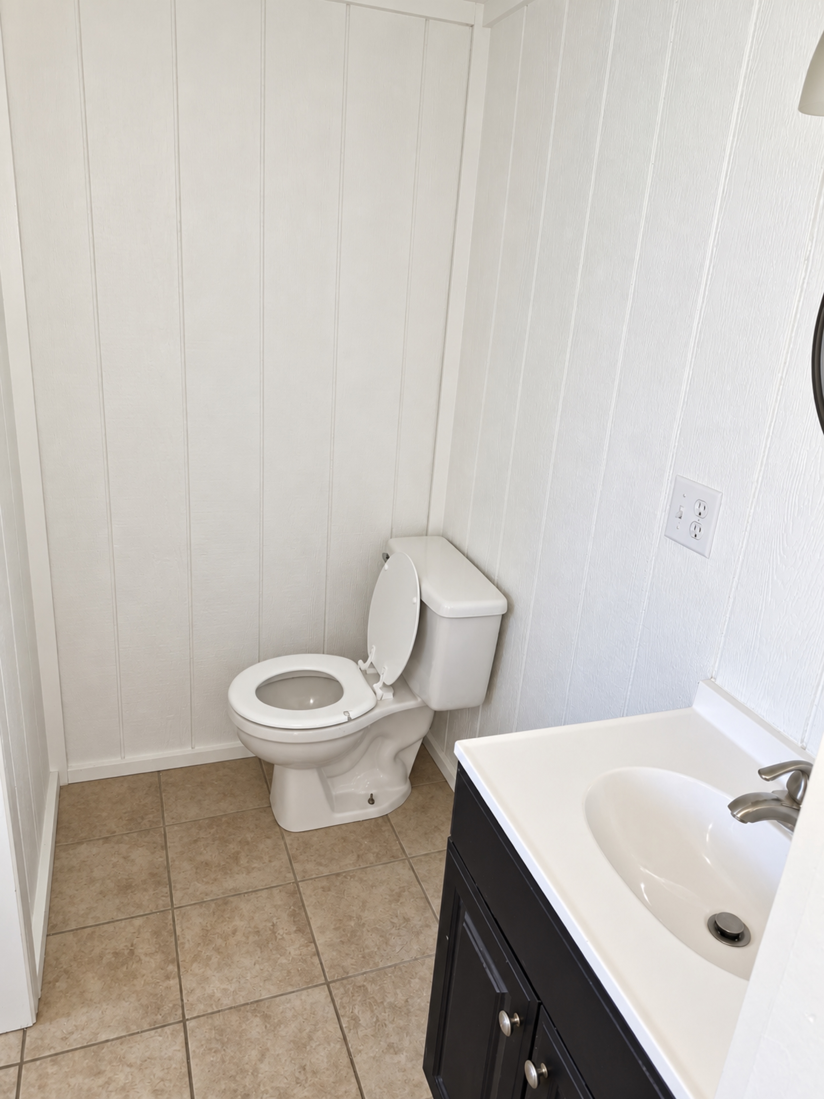 Finished bathroom with dark vanity and toilet