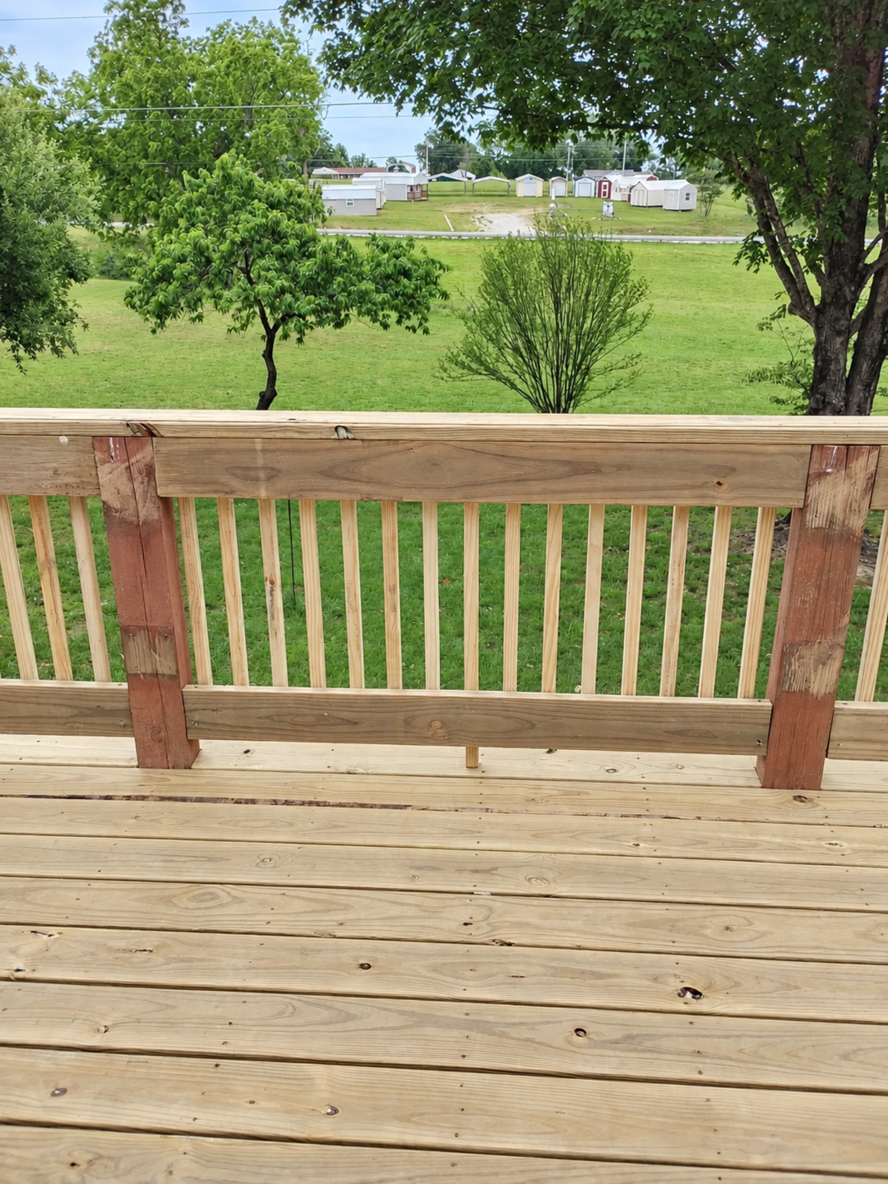New wood deck surface and railing overlooking the yard