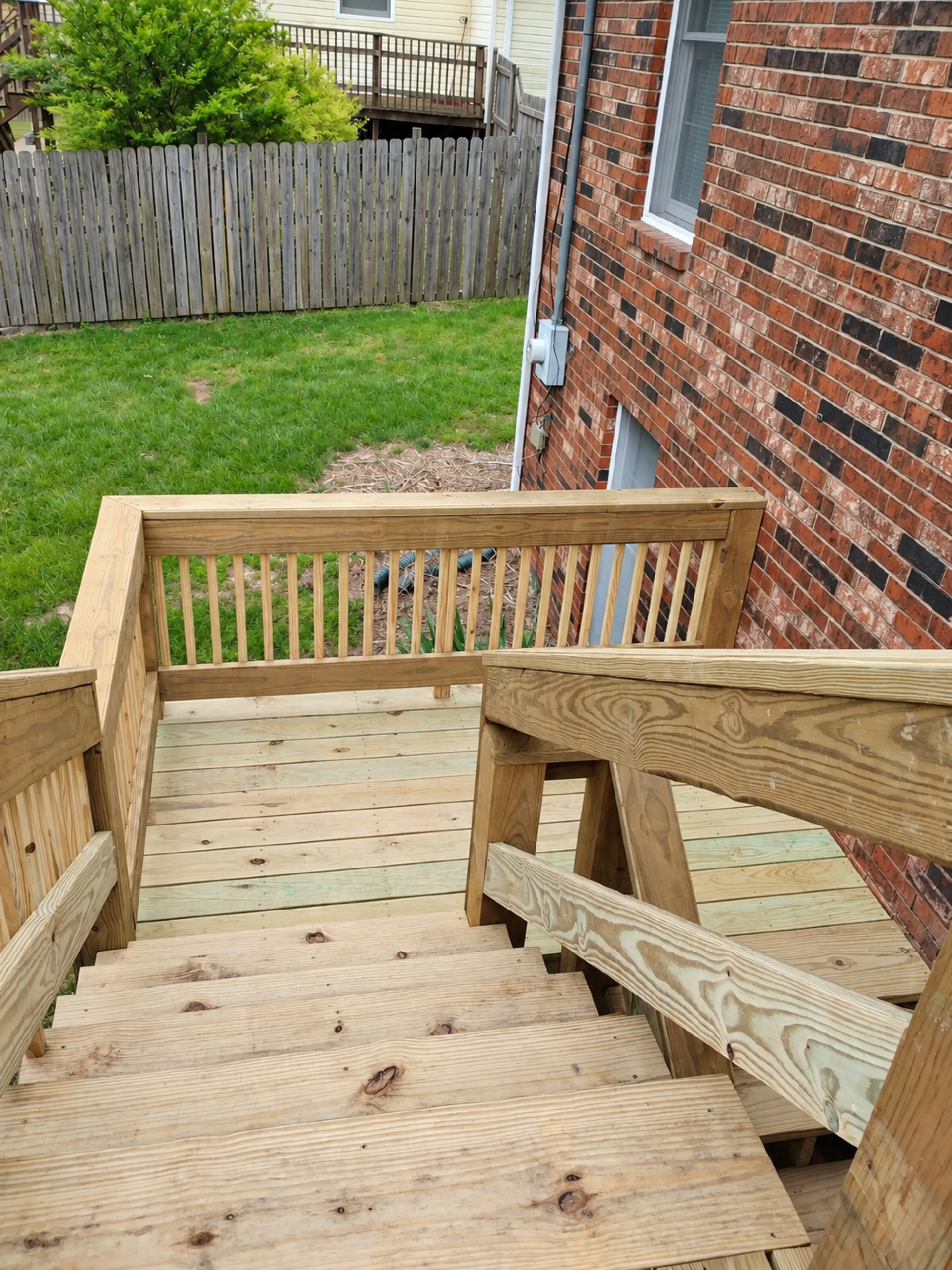New exterior stairs and intermediate landing beside a brick home
