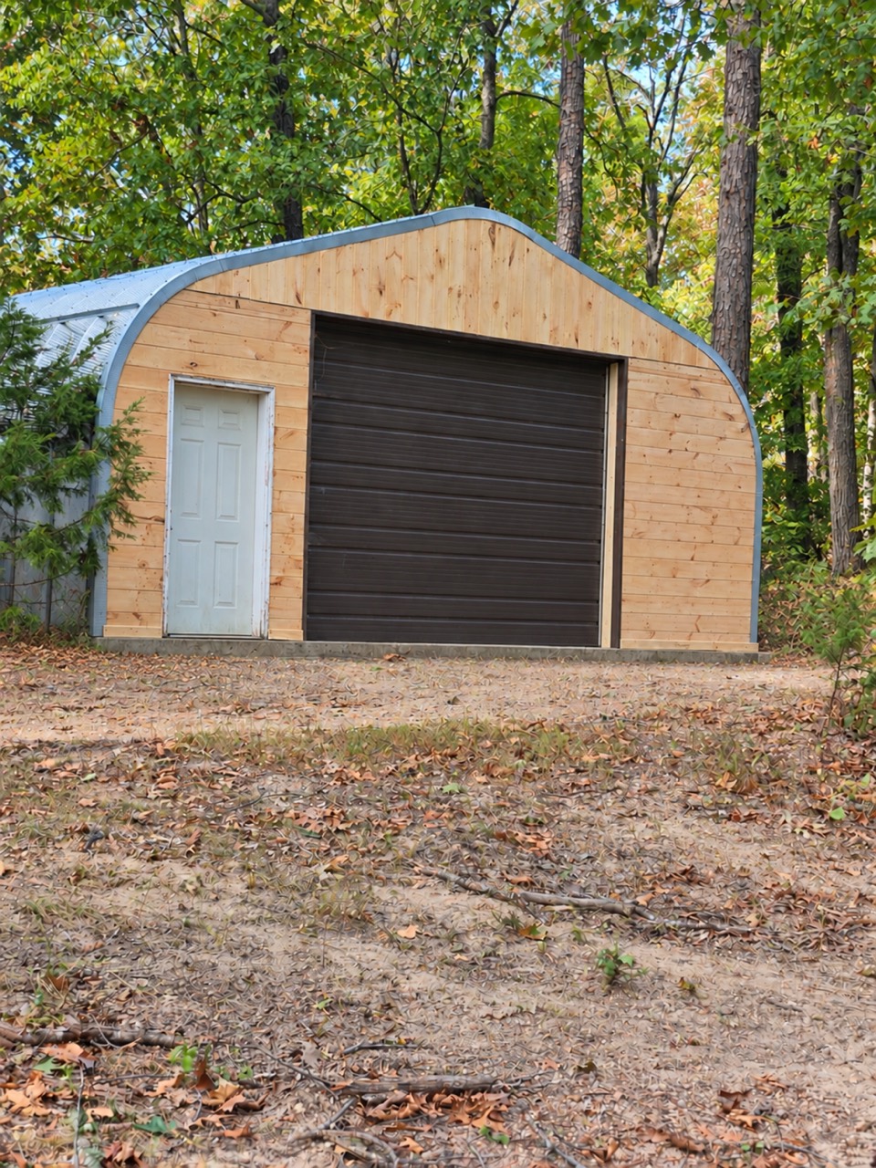 Garage front with new horizontal wood siding and vertical boards above the overhead door